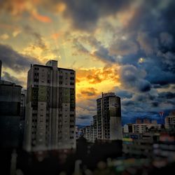 Buildings against cloudy sky at sunset