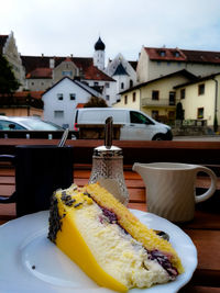 Close-up of breakfast on table against buildings