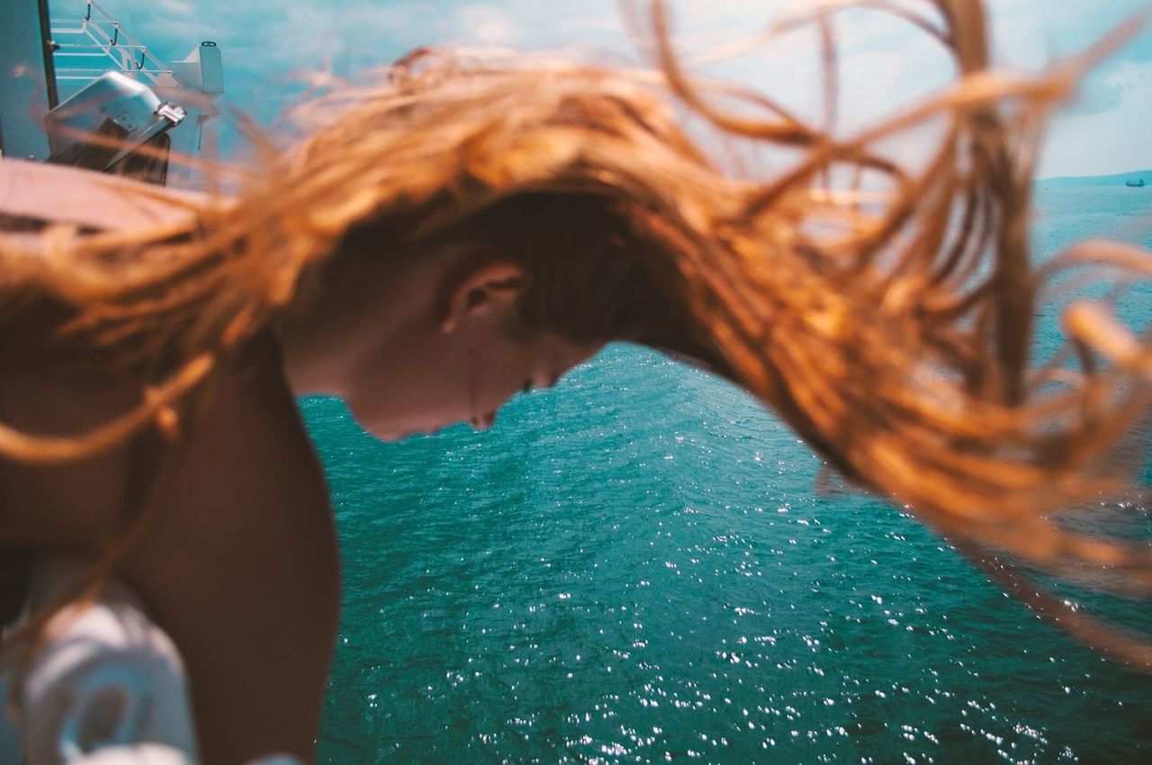 lifestyles, leisure activity, water, person, young adult, young women, headshot, portrait, looking at camera, long hair, smiling, focus on foreground, day, waist up, head and shoulders, casual clothing, close-up