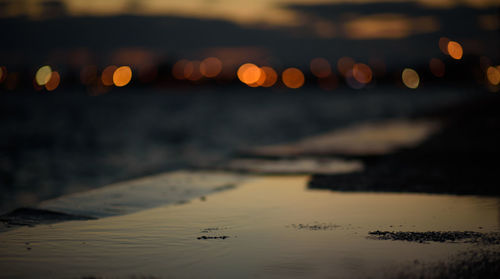 Surface level of beach against sky at sunset