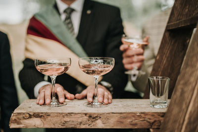 Midsection of man with drinks on table