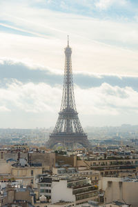 Communications tower in city against sky