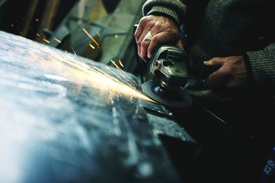 Midsection of man using circular saw at industry