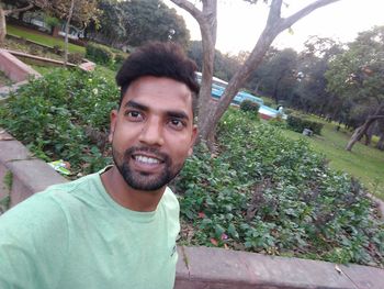Portrait of smiling young man against plants