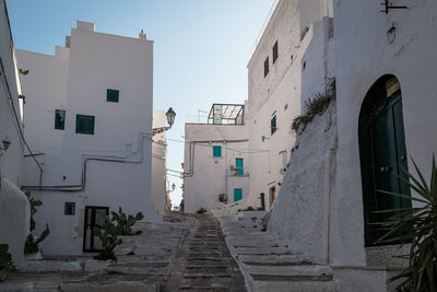 Narrow alley amidst buildings in city against sky