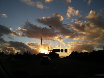 View of road against cloudy sky during sunset