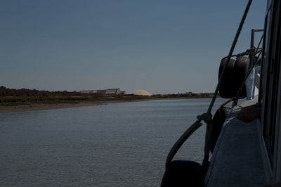 Boat sailing on river against clear sky