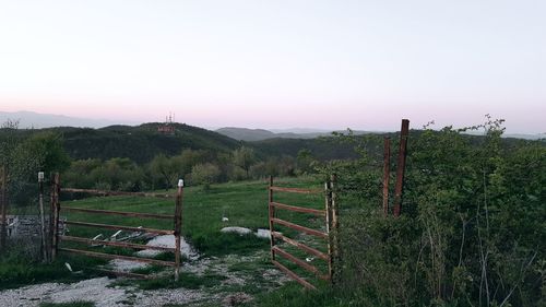 Fence on field against clear sky
