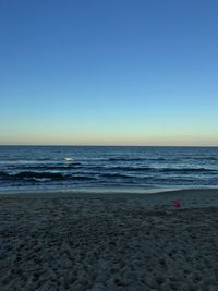 Scenic view of beach against clear blue sky