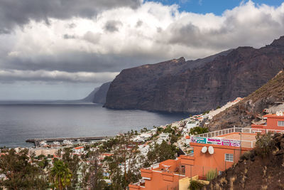 High angle view of townscape by sea against sky