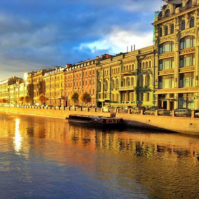 building exterior, architecture, built structure, water, sky, city, waterfront, canal, cloud - sky, building, transportation, residential structure, incidental people, residential building, city life, reflection, mode of transport, travel destinations, nautical vessel, old town