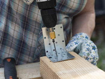 Low section of man holding wood