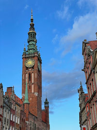 Low angle view of clock tower amidst buildings in city