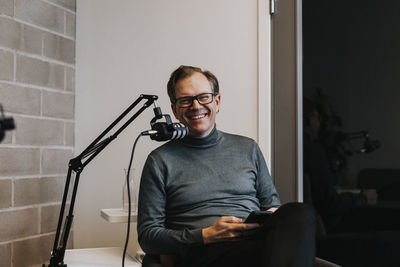 Smiling man in front of microphone