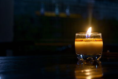 Close-up of lit tea light candle on table