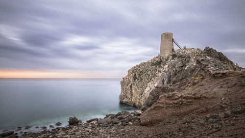 Scenic view of rocks on beach against sky