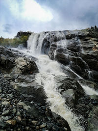 Scenic view of waterfall against sky