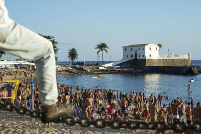 People at beach against clear sky