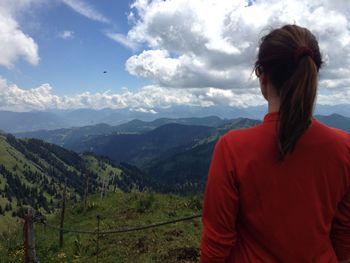 Rear view of man looking at mountains against sky