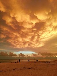 Scenic view of sea against cloudy sky during sunset