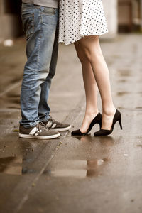 Low section of woman standing on footpath