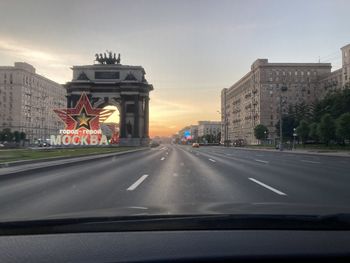 Road seen through car windshield during sunset