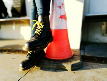 Low section of woman by traffic cone at street