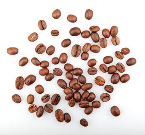 High angle view of coffee beans against white background