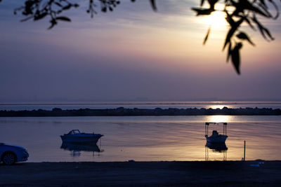 Silhouette boat on beach against sky during sunset