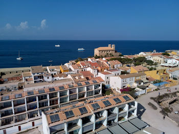 High angle view of buildings by sea against sky