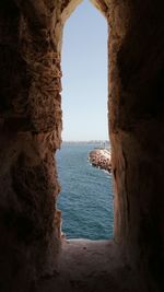 Scenic view of sea against clear sky seen through arch