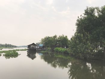 Reflection of trees in calm lake against sky