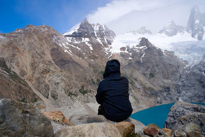 Rear view of man on snowcapped mountains against sky