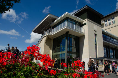 People on red building against sky