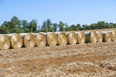 Hay bales on field against sky