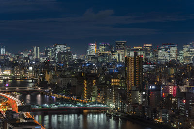 Illuminated buildings in city against sky at night