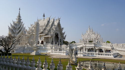 Panoramic view of pond and building against sky