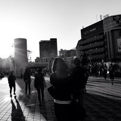 People on city street against clear sky