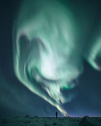 Low angle view of aurora borealis against sky at night