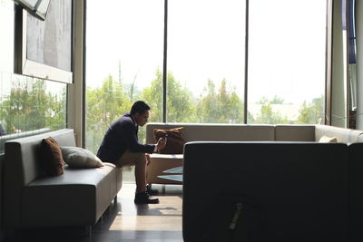 Rear view of woman using laptop at home