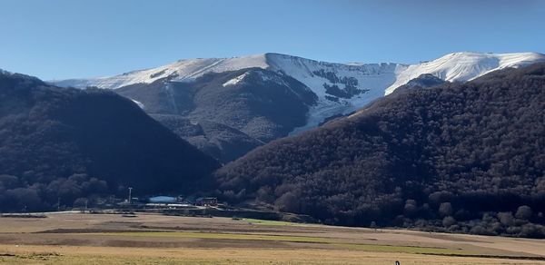 Scenic view of snowcapped mountains against clear sky