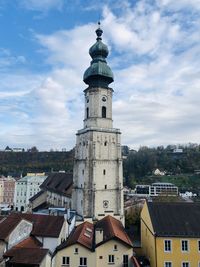 Buildings in town against cloudy sky