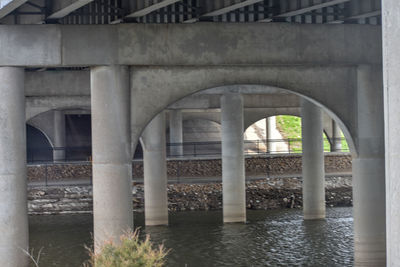 Arch bridge over river against building