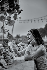 Young woman with flower petals on land against sky