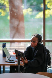 Portrait of young woman using laptop while sitting on table