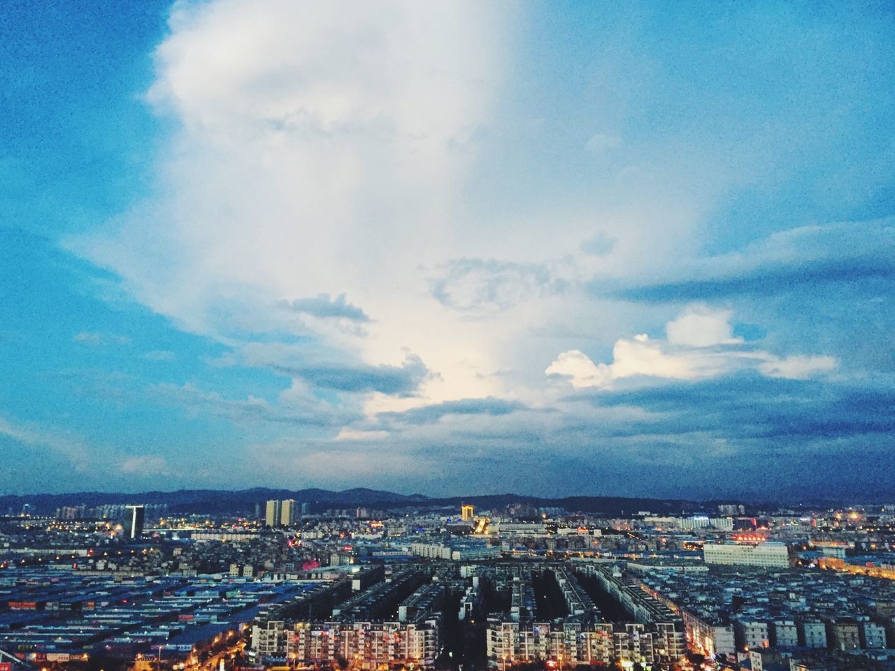 cityscape, city, architecture, building exterior, built structure, sky, crowded, cloud - sky, residential district, high angle view, blue, cloud, residential building, city life, cloudy, residential structure, aerial view, outdoors, skyscraper, river