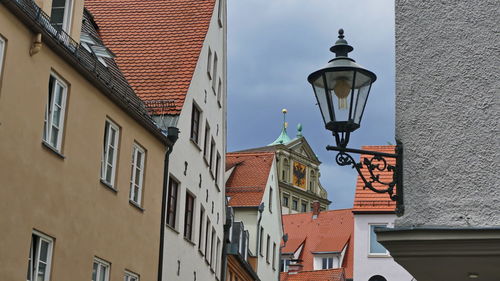 Low angle view of street light by building against sky