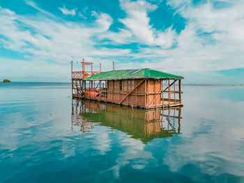 Lifeguard hut in sea against sky