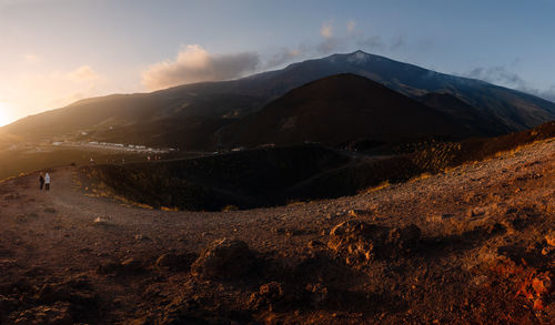 Scenic view of arid landscape against sky during sunset