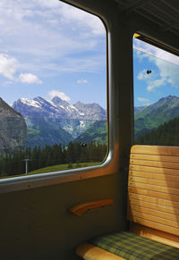 Scenic view of mountains against sky seen through window